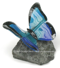 Glazen vlinder op basalt steen