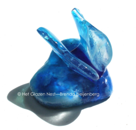Kleine blauwe vlinder op blauw hartje van glaskunst