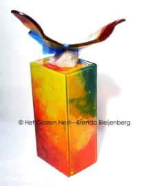 Kleurige vlinder op urn van glaskunst