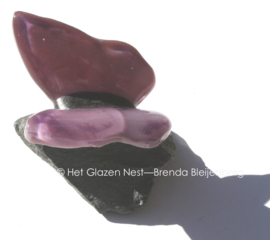 Kleine glasvlinder in oud paarse kleuren