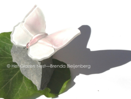 Wit en roze glazen vlinder op basalt
