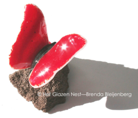 Rode glas vlinder op lavas steen