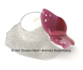 Kleine roze vlinder op waxinelichtje