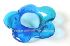 Kleine bloem in abstract aqua blauw glas