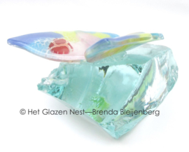 pastel kleurige vlinder op glas brok