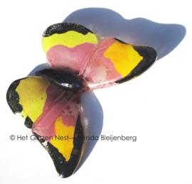 Kleine vlinder in roze en geel glas