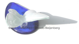 Witte vlinder op blauwe druppel van glas