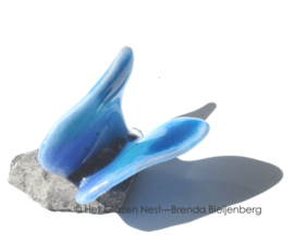 Kleine vlinder in aqua blauw glas