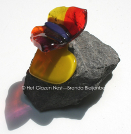 Vlindertje op geel hartje op steen