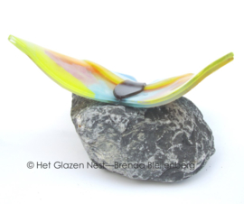 vlinder in pastel kleuren op basalt steen