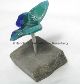 Kleine blauw groene vlinder op ruwe steen