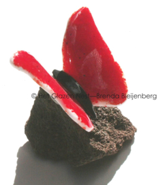 Rode glas vlinder op lavas steen