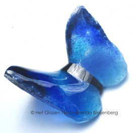 Blauwe vlinder in lichtdoorlatend glas