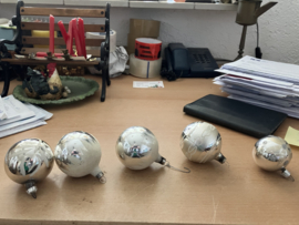 Diverse zilverkleurige kerstballen, papier mache paddenstoeltjes, kersthuisje