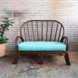 Vintage rotan bank met turquoise kussens