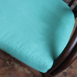 Vintage rotan bank met turquoise kussens