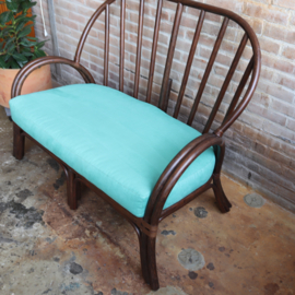 Vintage rotan bank met turquoise kussens