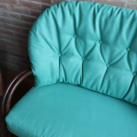 Vintage rotan bank met turquoise kussens