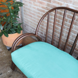 Vintage rotan bank met turquoise kussens