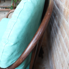 Vintage rotan bank met turquoise kussens