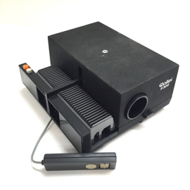 Nr.8691 -- Rollei P300 mooie kleinbeeld 5 x 5 cm dia projector Universeel Magazijn , scherpstelling via afstandsbediening: ja Lens: Heidosmat 2,8/85 Lamp: 24V 150W, steeklampje  heeft service beurt gehad en werkt prima~