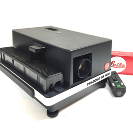 Nr.8779 --  Leitz pradovit CA1500 Prof. kleinbeeld dia projector (5x5cm) metalen uitvoering,  Leitz colorplan 2.5/90 lens, autm.scherpstelling, halogeenlamp 150W. incl.diaslede en afstandsbediening, projector heeft service beurt gehad en is in nieuwstaat