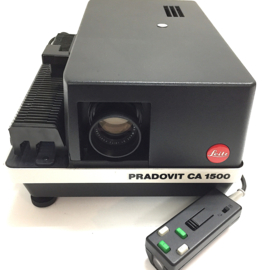 Nr.8779 --  Leitz pradovit CA1500 Prof. kleinbeeld dia projector (5x5cm) metalen uitvoering,  Leitz colorplan 2.5/90 lens, autm.scherpstelling, halogeenlamp 150W. incl.diaslede en afstandsbediening, projector heeft service beurt gehad en is in nieuwstaat