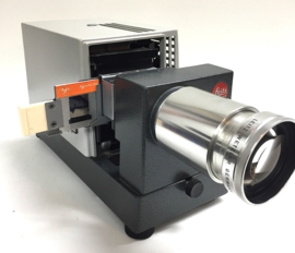 Nr.8144 -- prachtige  Leitz Prado Universal , kleinbeeld ( 5x5 cm )dia projector met zware Halogeenlamp Lamp: 24V 250W  Lens: Leitz Wetzlar Elmaron 2,8/150mm  met kleinbeeld dia houder, is in perfecte staat heeft service beurt gehad en werkt goed.
