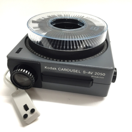 Nr.88705 - mooie KODAK Carousel S-AV 2050 zware projector voor kleinbeeld dia's (5x5cm) met Kodak vario Retinar zoomlens 70 - 120mm  lens ,halogeenlamp 24V-250W.met afstands bediening en carousel , heeft service beurt gehad en is in prima staat