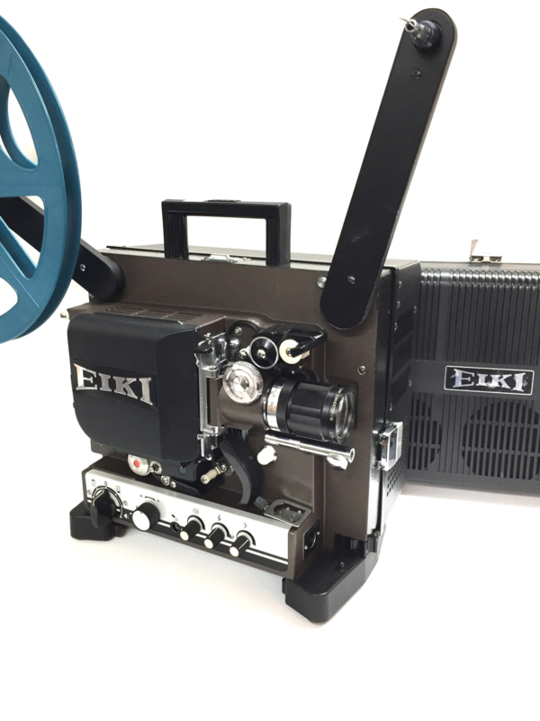 Nr.8352 -prachtige 16mm Eiki NT projector met 50mm lens en converter voor extra grootbeeld, halogeenlamp 24V 250W.  versterker 20 Watt, optisch/magnetisch geluid, , spiekerkap, heeft service beurt gehad en is in zeer goede staat.