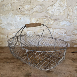 BU20110182 Oude Franse draadgaas oogstmand met houten handvat in mooi verweerde staat, zie foto's voor details. Afmeting: 52,5 cm lang /  15,5 cm hoog (tot hengsel) / 28,5 cm hoog (t/m hengsel) /  32,5 cm doorsnede