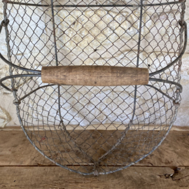 BU20110182 Oude Franse draadgaas oogstmand met houten handvat in mooi verweerde staat, zie foto's voor details. Afmeting: 52,5 cm lang /  15,5 cm hoog (tot hengsel) / 28,5 cm hoog (t/m hengsel) /  32,5 cm doorsnede