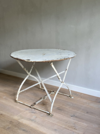 BU20110136 Antieke Franse opklapbare ronde tuintafel uitgevoerd in zwaar ijzer met een prachtig onderstel. Periode 1900-1920. In verweerde, maar prachtige staat! Afmeting: 90 cm doorsnede / / 72 cm hoog. Alleen ophalen in winkel.