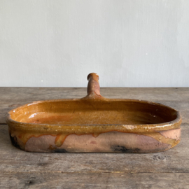 AW20111181 Antique, rustic French earthenware baking dish, unfortunately missing a piece of the bottom edge, but otherwise in beautiful condition! Size: 32.5 cm long / 5.5 cm high / 16.5 cm cross section.