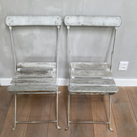 OV20110866 Set of 2 old French folding iron terrace chairs with original off-white color wooden slats seat and backrest and ... in beautiful usable condition! Size: 42.5 cm. high (to the seat) / 36 cm. wide. Pick up in my store only.