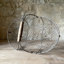 BU20110182 Old French wire mesh harvest basket with wooden handle in beautiful weathered condition, see photos for details. Size: 52.5 cm long / 15.5 cm high (to handle) / 28.5 cm high (including handle) / 32.5 cm cross section.