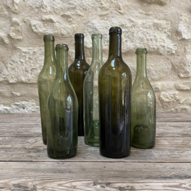 OV20111115 Set van 6 antieke wijnflessen van mondgeblazen glas in verschillende prachtige tinten groen met de zogenaamde "geest in de fles bodem"  in prachtige staat! Afmeting: grootste fles 31 cm hoog / kleinste fles 25,5 cm hoog
