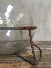OV20110691 Unique old French wine bottle in beautifully weathered iron holder. The wine bottle is anchored in the holder. In beautiful condition! Size: +/- 70 cm. high / +/- 55 cm. intersection. Pickup only.