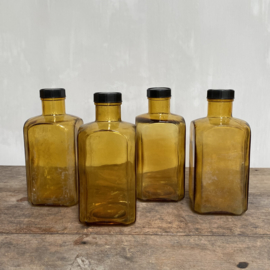 OV20110769 Set of 4 old square French stock bottles of mouth-blown (in mould) glass in beautifully weathered amber colour, all 4 in perfect condition! The screw caps are made of bakelite content: 1000 ml. Size: 21 cm. high / 9.5 cm. wide