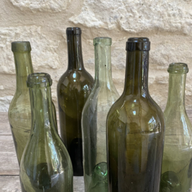 OV20111115 Set van 6 antieke wijnflessen van mondgeblazen glas in verschillende prachtige tinten groen met de zogenaamde "geest in de fles bodem"  in prachtige staat! Afmeting: grootste fles 31 cm hoog / kleinste fles 25,5 cm hoog