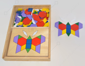 Vintage spel bestaande uit een houten kistje met tangram puzzels en voorbeelden