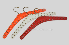 Set of three vintage vinyl coat hangers in red, white and orange with metal studs