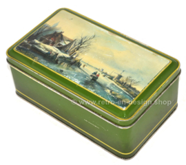 Green vintage biscuit tin with a Dutch scene in a winter landscape