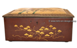 Rectangular tin drum on which birds embossed on a branch and leaf motifs, with keyhole