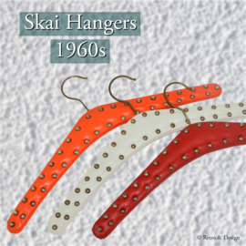 Set van drie vintage skai kledinghangers in rood, wit en oranje met metalen studs