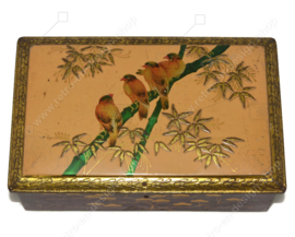 Rectangular tin drum on which birds on a branch and leaf motifs in relief, with lock