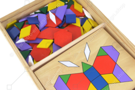 Vintage spel bestaande uit een houten kistje met tangram puzzels en voorbeelden