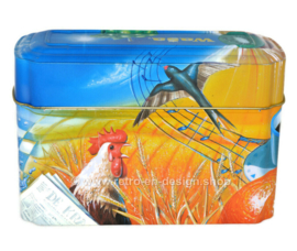 ​Orange and blue tin box for Wasa Crackers with images of a rooster, bee, sunflower, grain and fruit