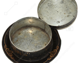 Antique round decorative tin with accompanying saucer