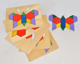 Vintage spel bestaande uit een houten kistje met tangram puzzels en voorbeelden